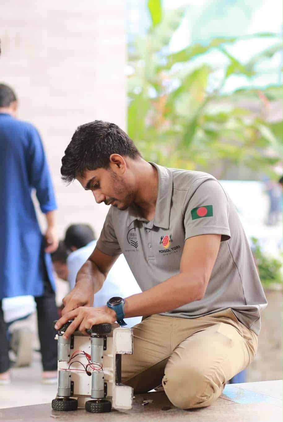 Participant adjusting a robot at an event